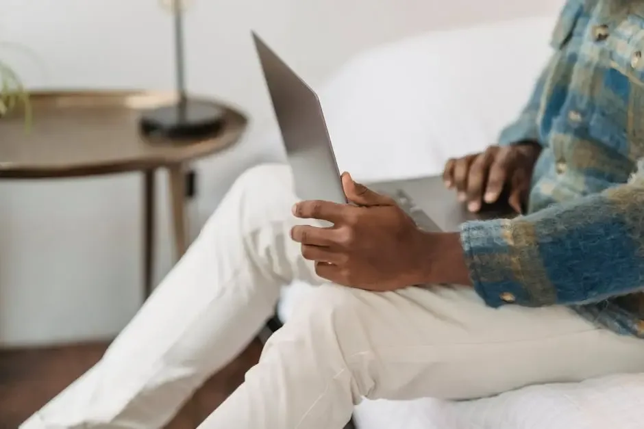 Side view of a man working on a laptop in a cozy home environment. Perfect for freelance and remote work concepts.